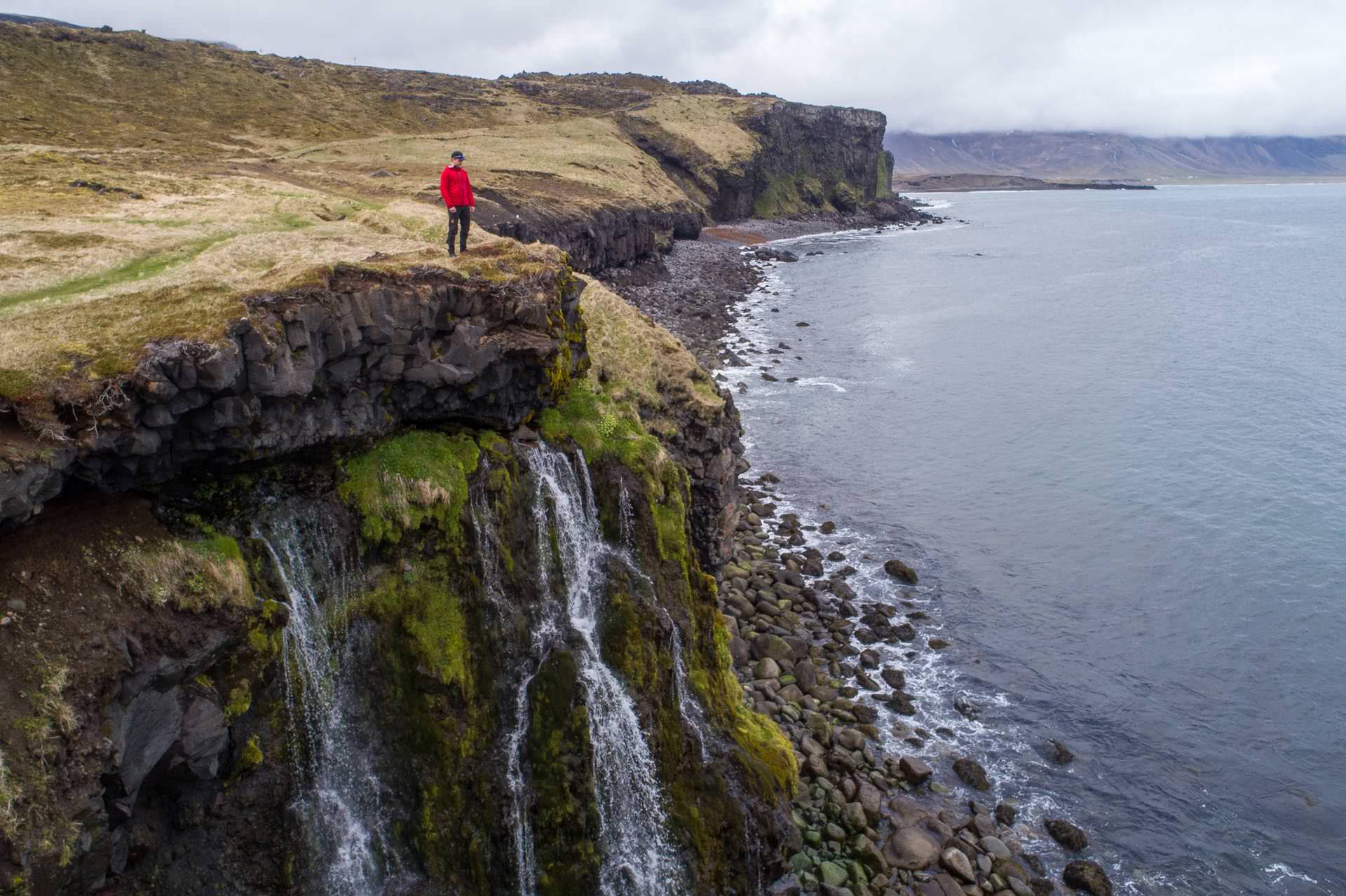 Waterfalls tumbling off green sea cliffs on the coast of Iceland
