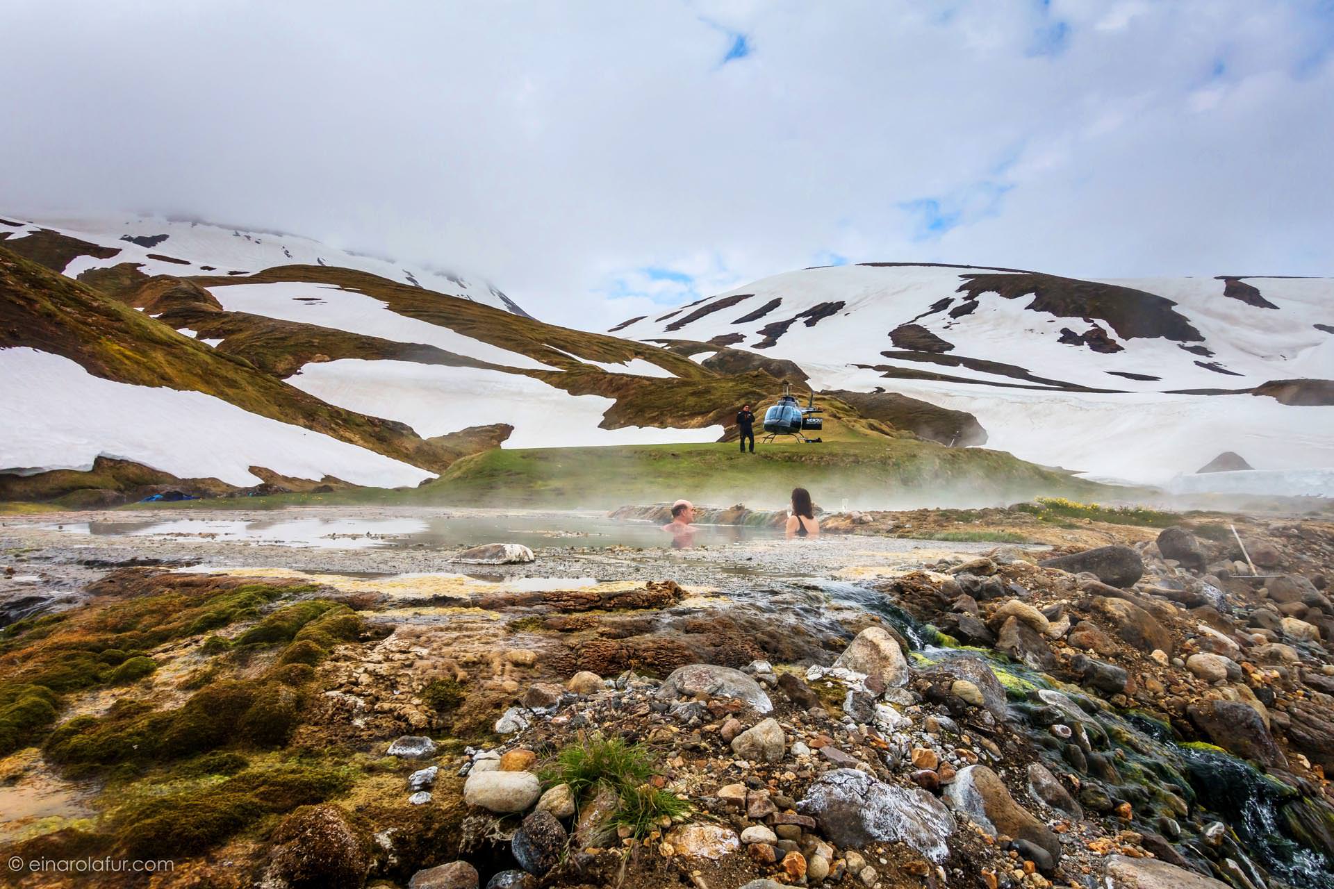 Steaming geothermal lagoon surrounded by snow-dusted hills in Iceland
