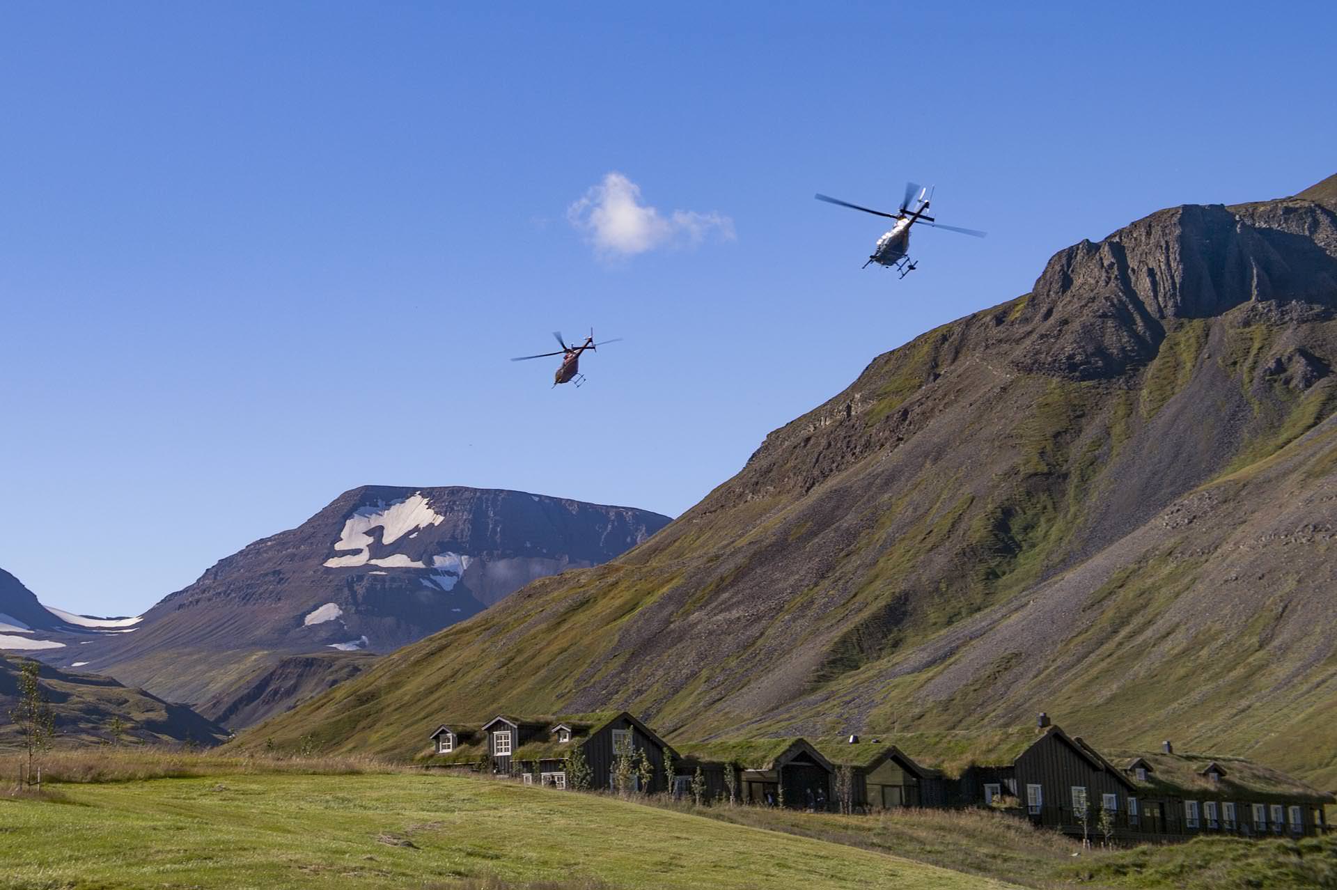 Helicopter flying over green mountains in northern Iceland in summer