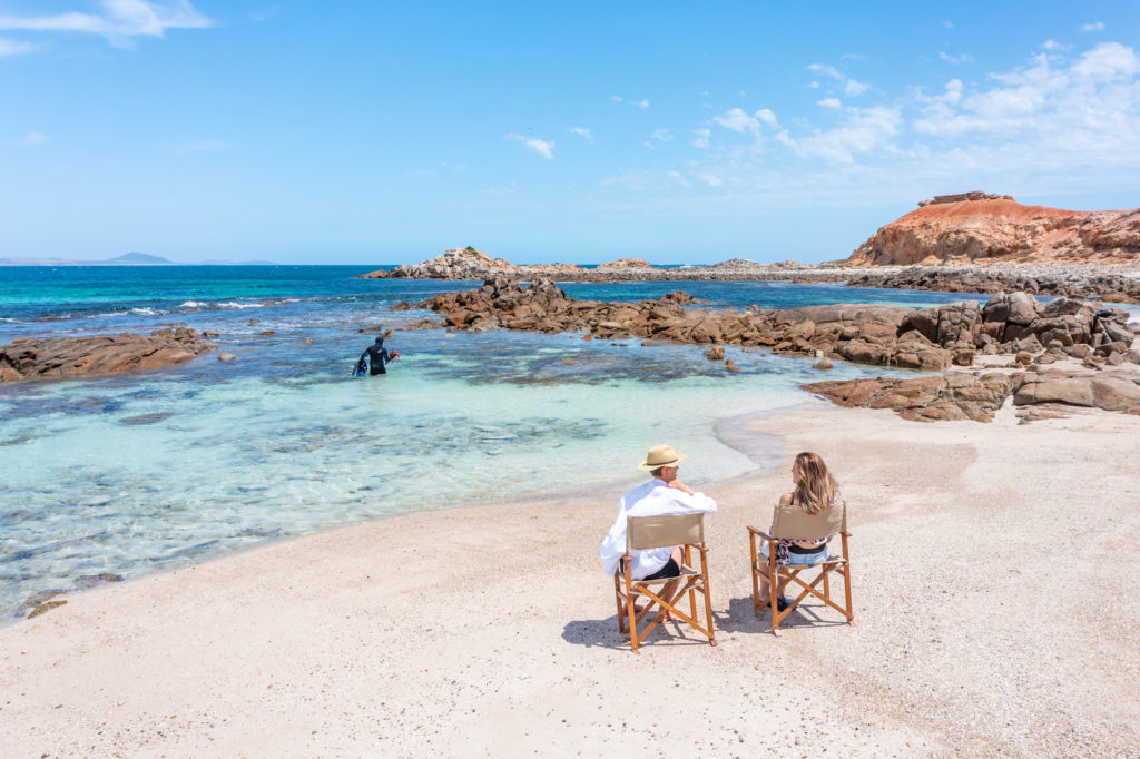 relax on the beach in australia while guide dives for lobster