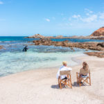 relax on the beach in australia while guide dives for lobster