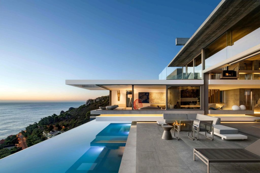 Modern clifftop villa with infinity pool and open living spaces, blending interior comfort with expansive ocean views