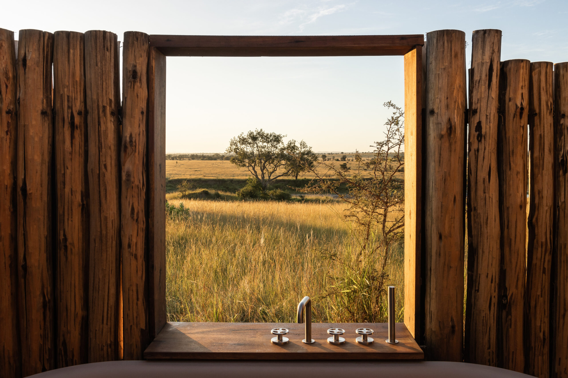 Outdoor bathtub at a luxury safari lodge overlooking the African savanna.
