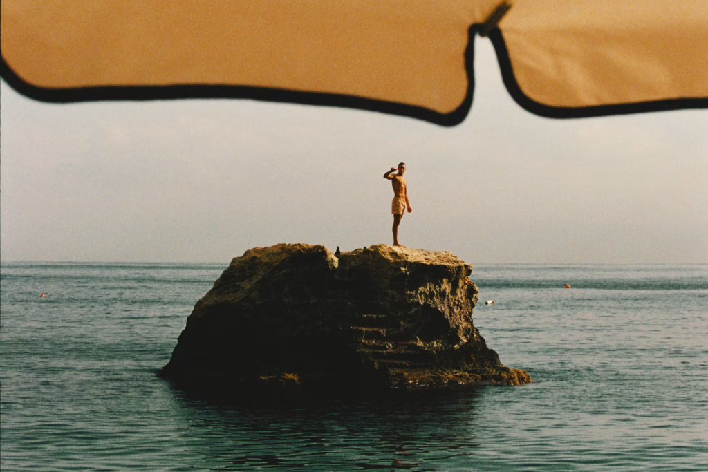 Traveler standing on a rock in the ocean representing freedom and decision-free all-inclusive vacations