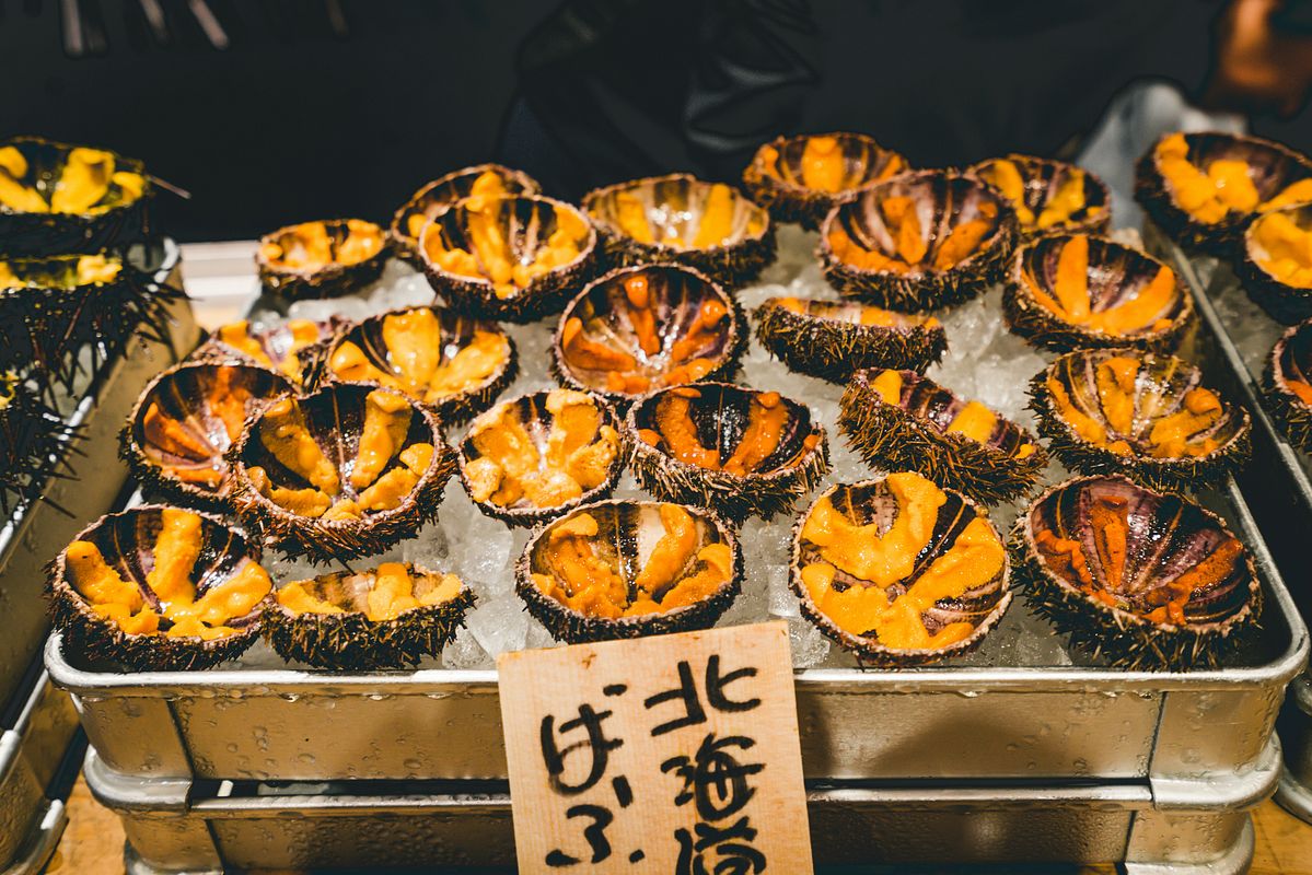 Fresh sea urchin (uni) split open on ice at a Japanese seafood market stall